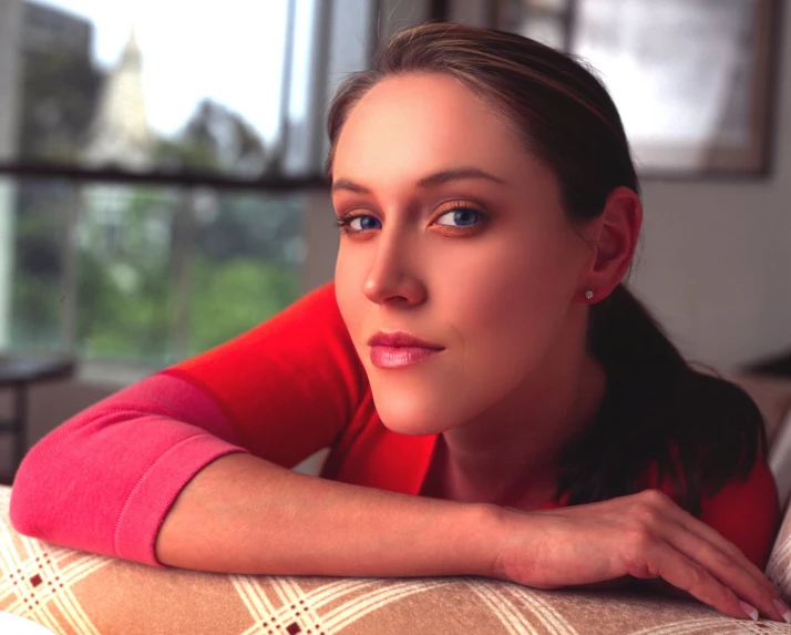 a woman is posing on top of a couch