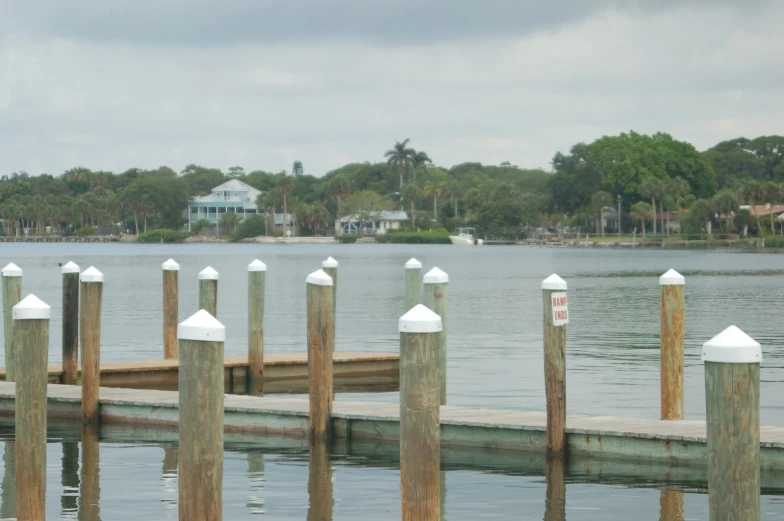 a dock in a city with white post fenced by water