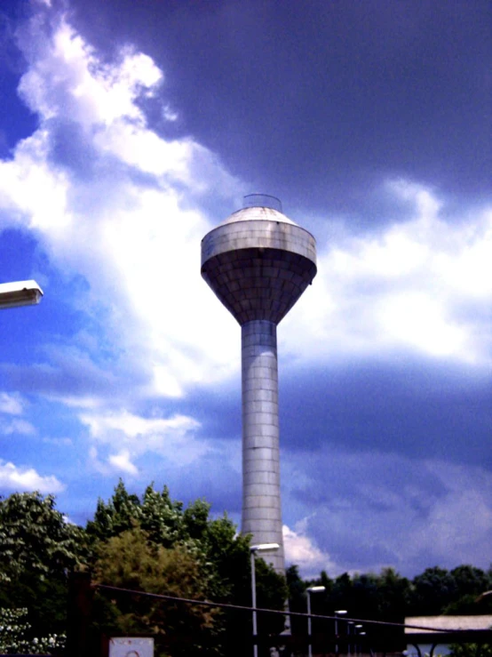 a water tower with clouds in the background