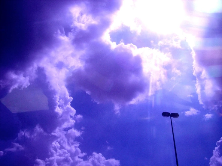 the sky is filled with clouds and a street light