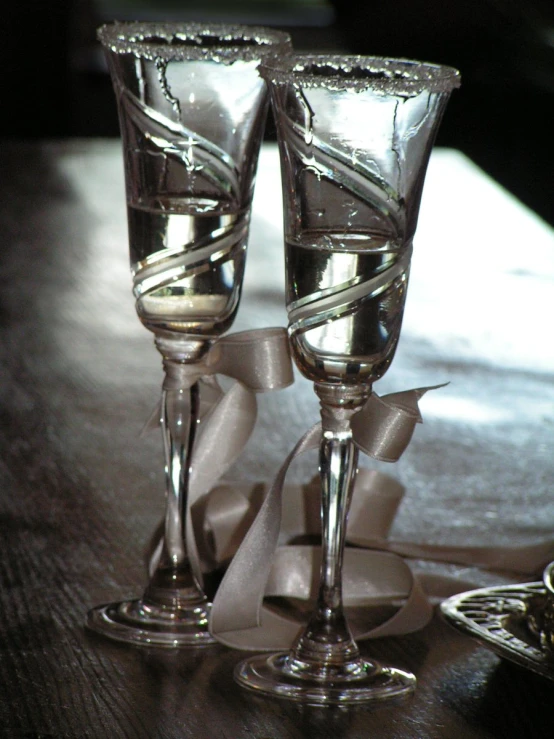 two silver cups are placed on a brown table