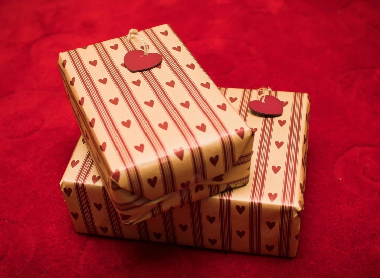 a pair of boxes with hearts are on a red blanket