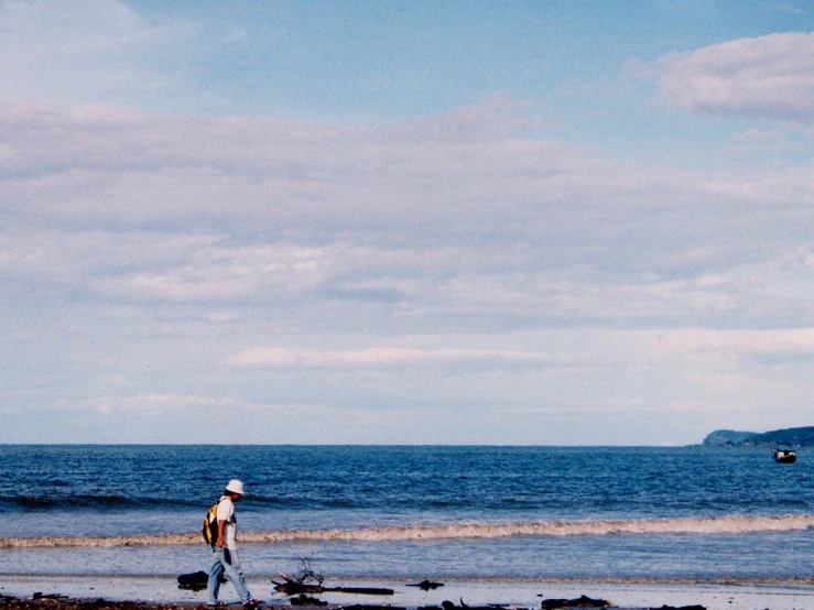 there is a man that is walking down the beach