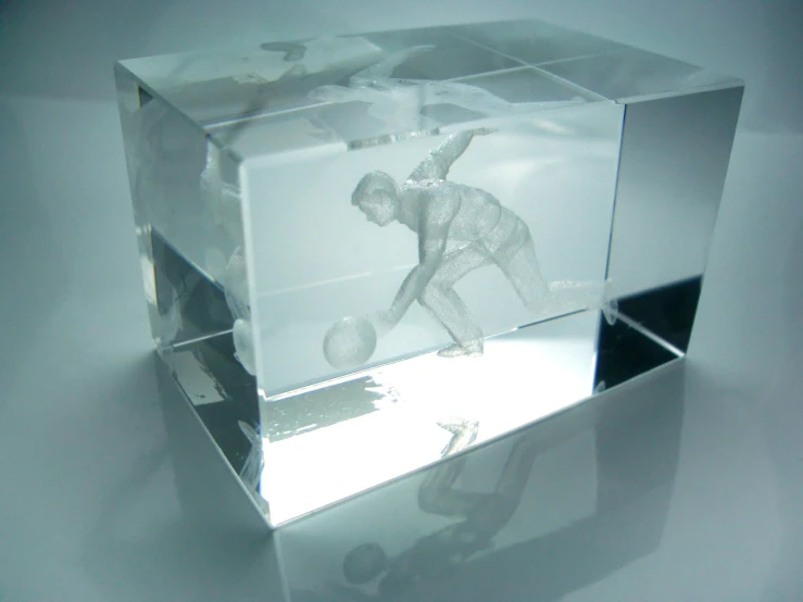 an illuminated glass block with a reflection of a man playing tennis