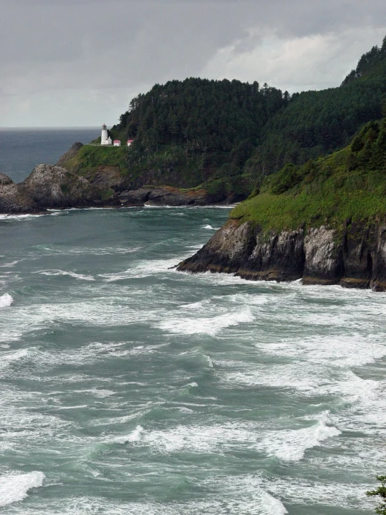 an ocean view with a boat traveling near a lighthouse