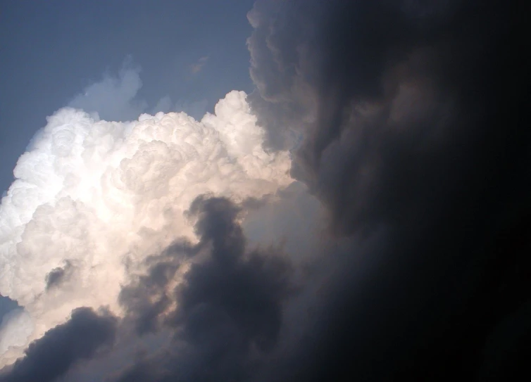 a large, dark cloud hovers above a dark, dreary sky