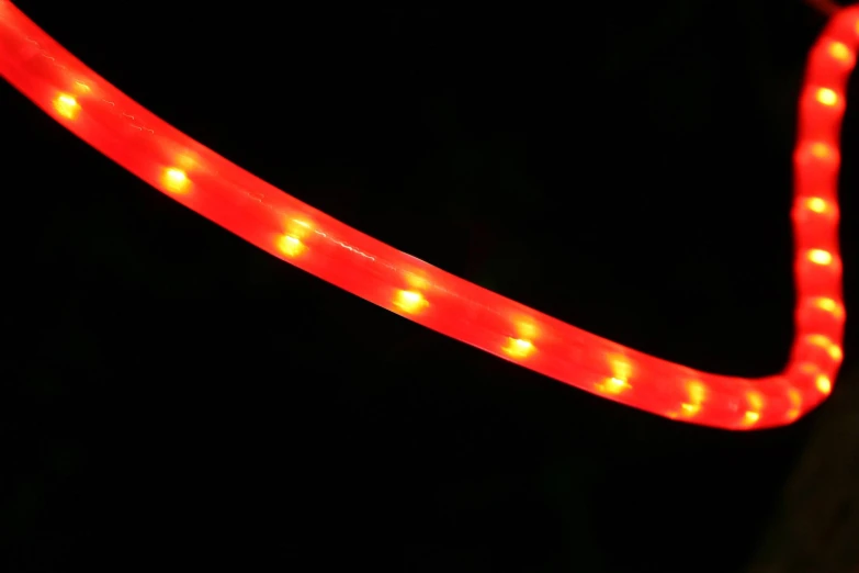 a lighted tube sitting in the darkness on a dark background