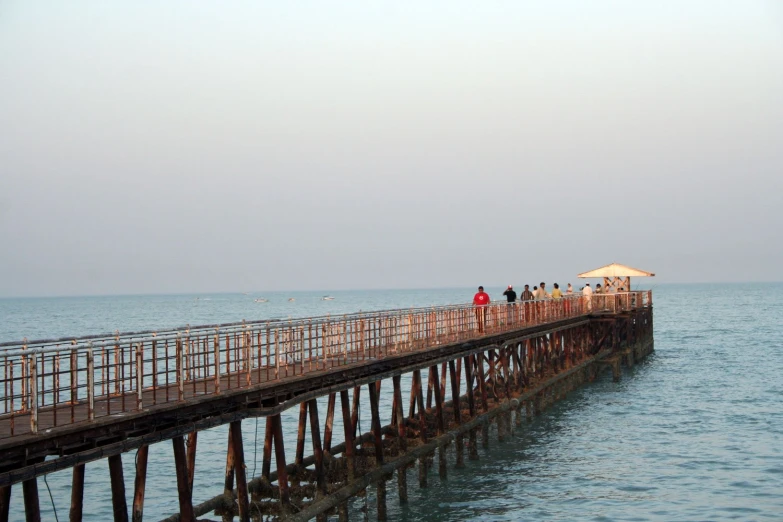 people standing on a wooden pier near the ocean