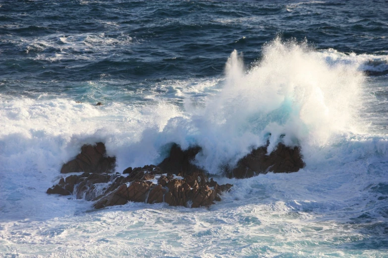 waves are crashing against the rocks in the ocean