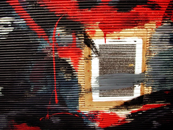 a red black and white object with paint over the door