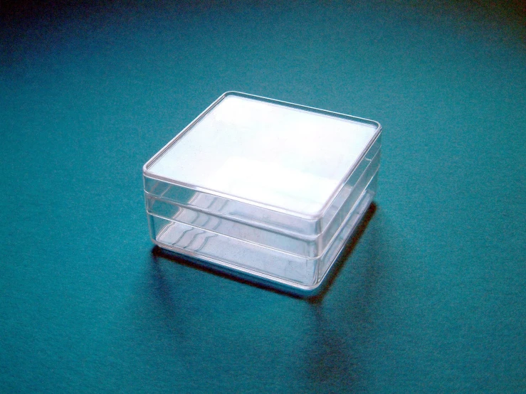 two small plastic storage containers with lids on a blue surface