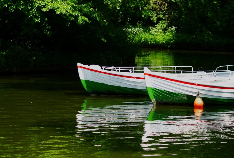 two green and white boats on calm water