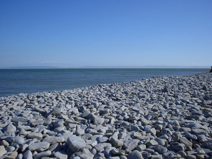 a bunch of rocks in the foreground with an ocean in the background