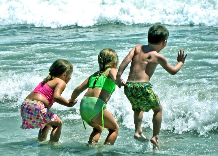 a few s running through the waves on the beach