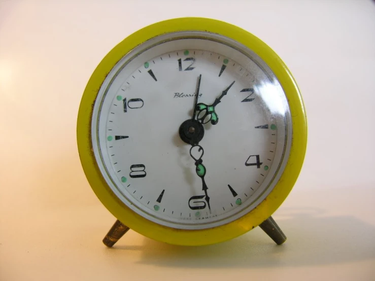 a yellow and white alarm clock sitting on a counter top