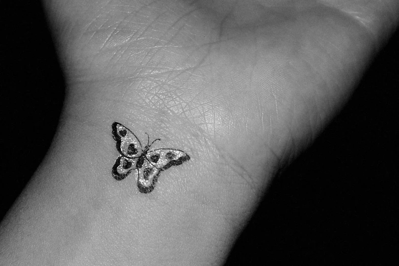 a small erfly tattoo on the wrist
