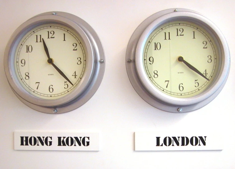 two clocks hanging on the wall next to each other