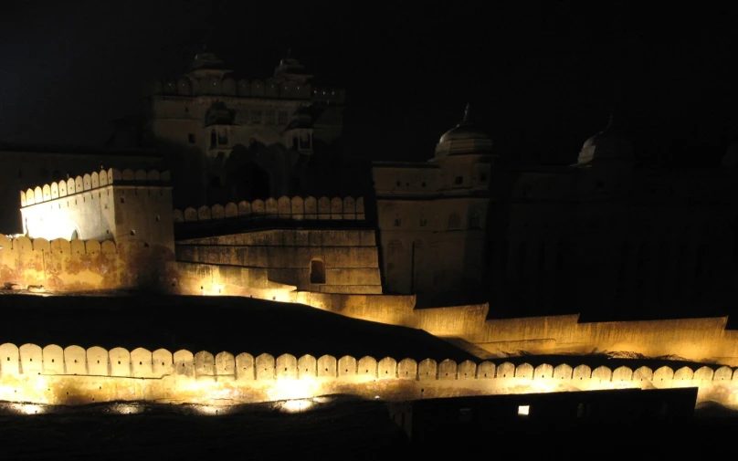 a castle that has lights on it and a light up building near by