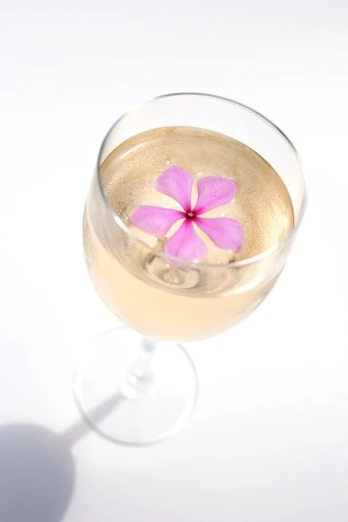 a glass of wine with flowers sitting in it