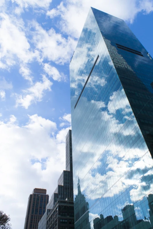 the high rise building with mirrored windows appears to be reflecting the clouds