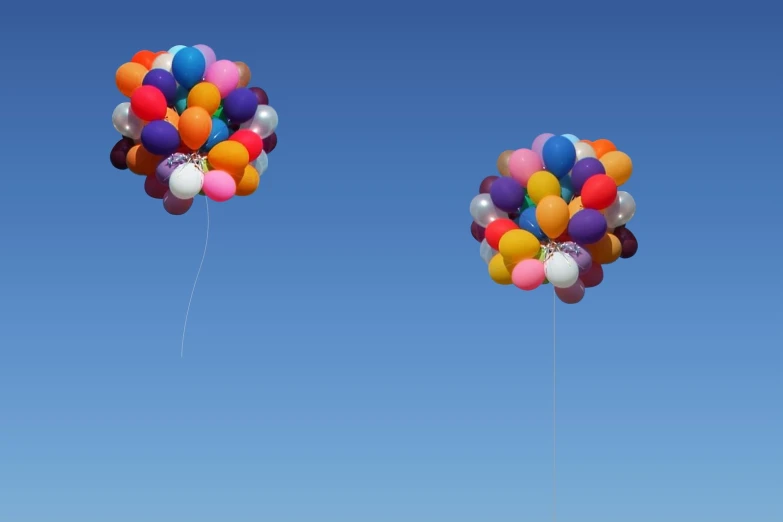 a small boy holding onto a bunch of balloons