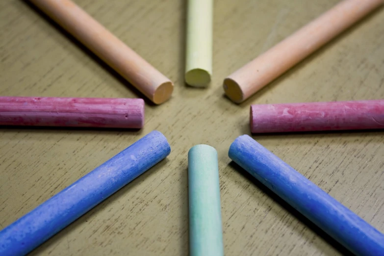 the blue and pink pencils are on the table