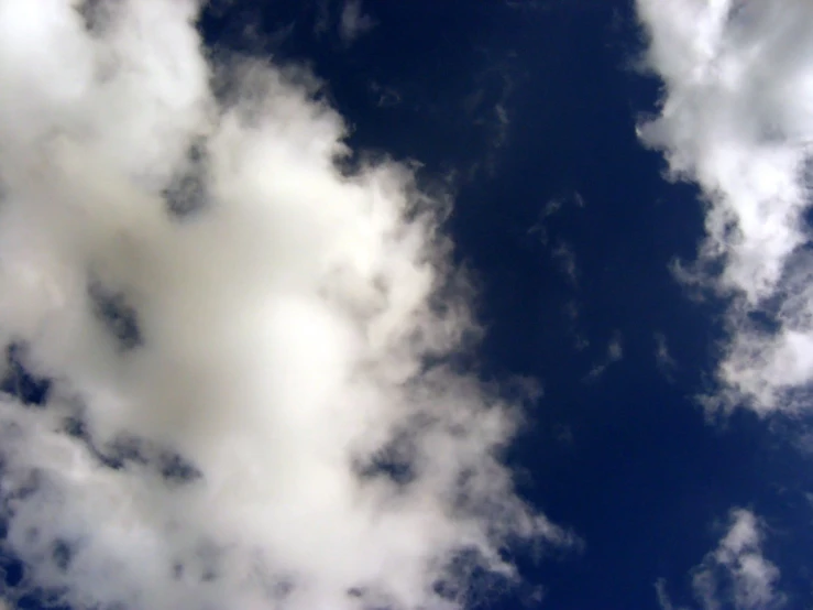 a very cloudy sky with some small airplanes in the distance