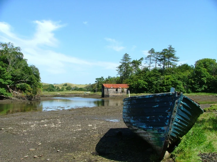 a fishing boat with no front end on shore by water