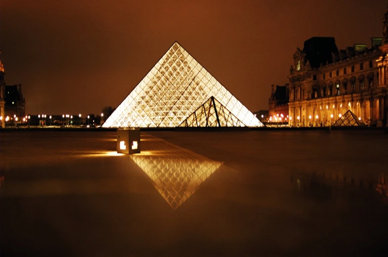 a tall white pyramid lit up in front of a building
