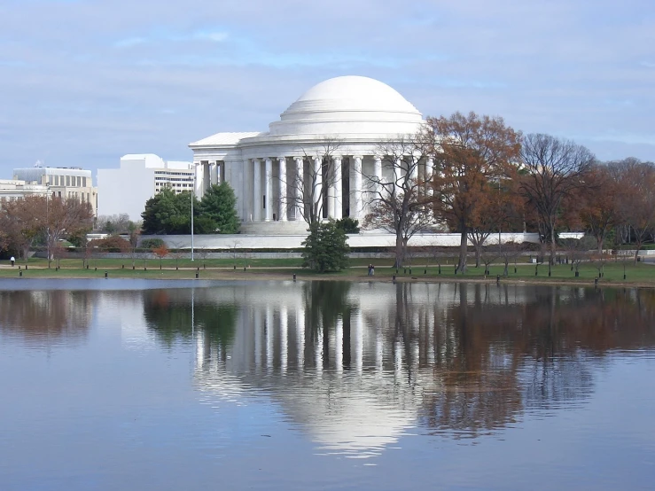 the view of a large dome with a roof is overlooking a body of water and trees