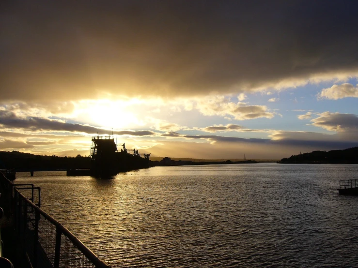 a sunset is shown as boats go in the water