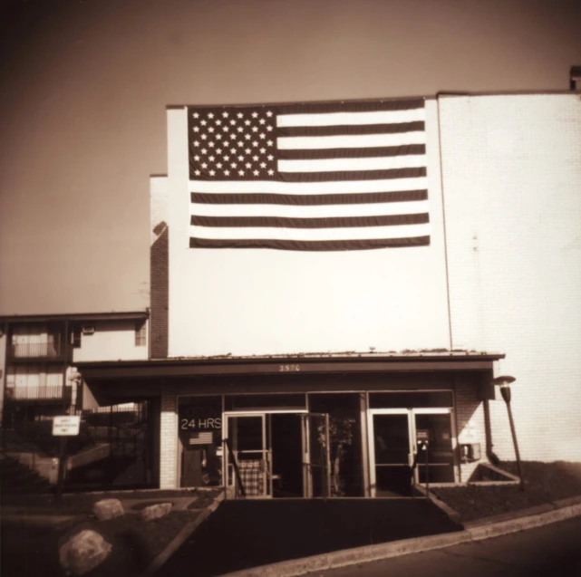 an american flag flying in front of an old fashioned building