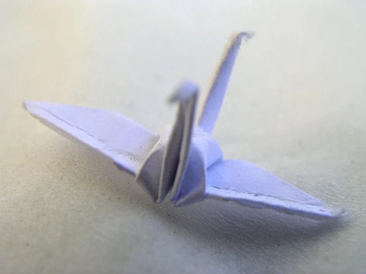 an origami style paper airplane on the ground