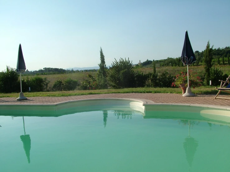 an empty pool is surrounded by flags in the sun