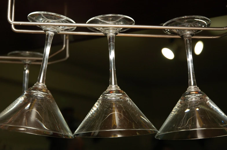 four wine glasses in a line lined up on a rack