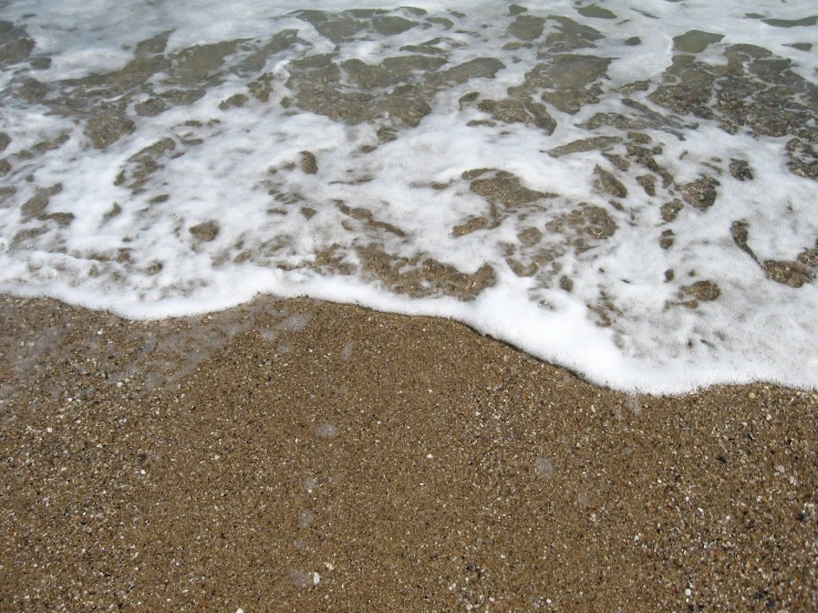 the water is splashing in to shore next to the shore line