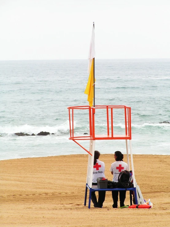 two people sitting on a bench in front of the ocean
