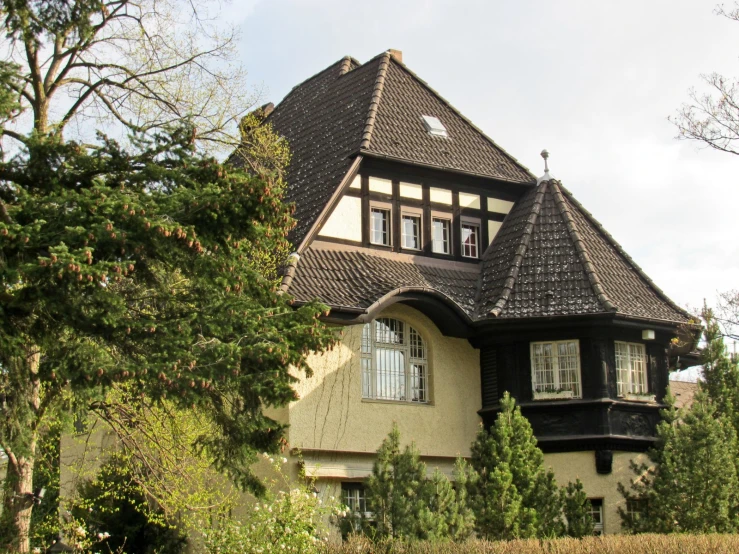 the house is made of wood and is surrounded by bushes