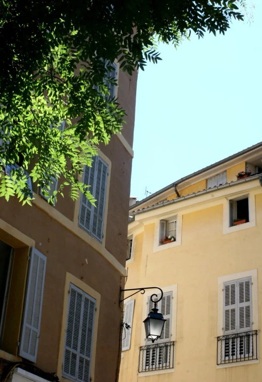 a tall building sitting next to a tree and another building