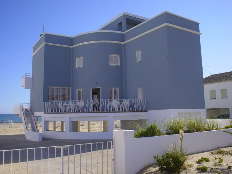 a large house sitting on top of a sandy beach