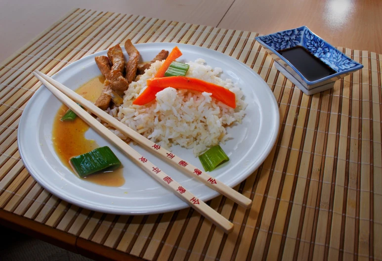 a plate with rice, carrots and other veggies