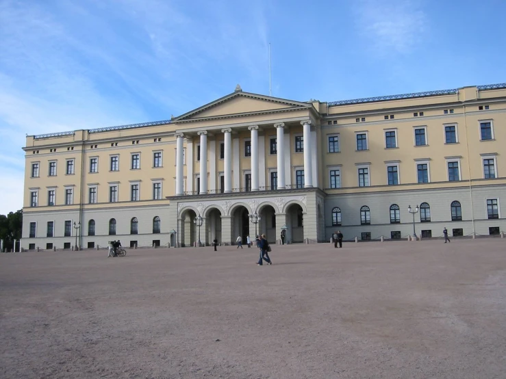 people are walking and talking in front of a large building