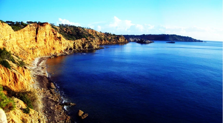 a cliff side is shown with a beautiful beach