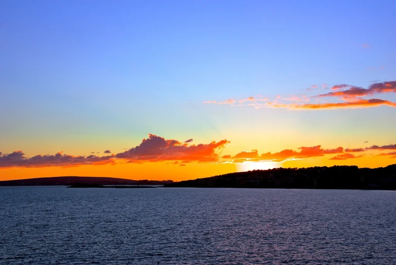 a boat is out in the water during sunset