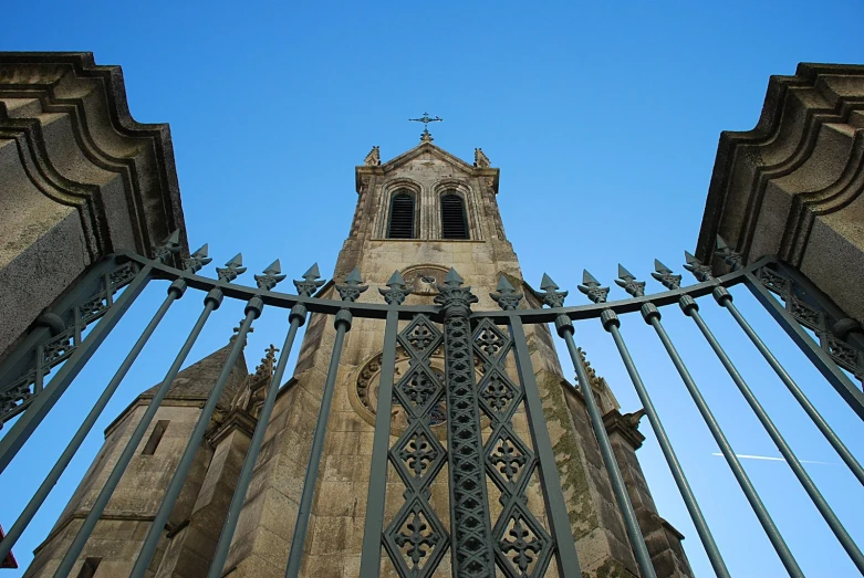 an old clock tower seen from behind a fence