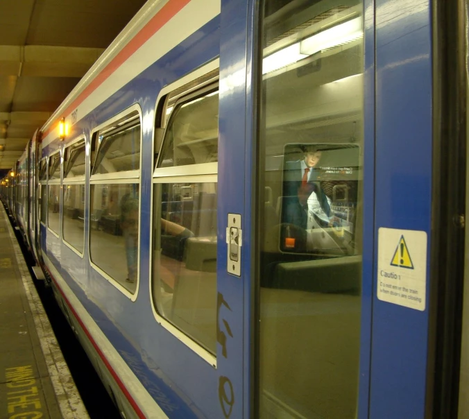 a blue and white train pulling into the station