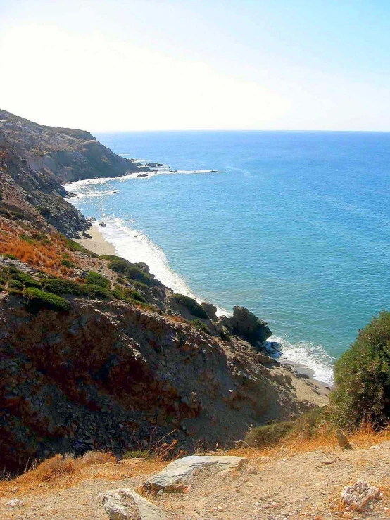 a steep cliff along the coast, with water at its foot