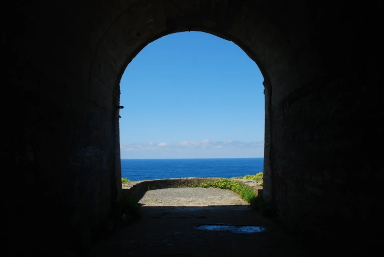 a archway with the sea as the backdrop