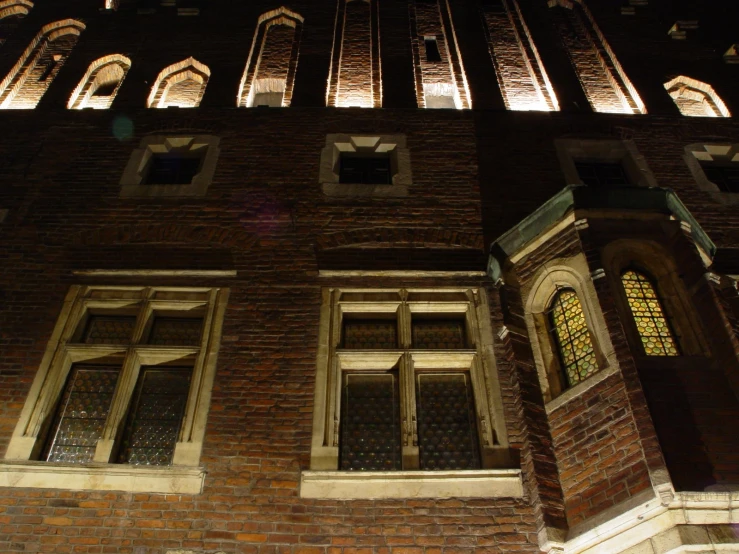 a brick building has four windows with lots of light shining on them