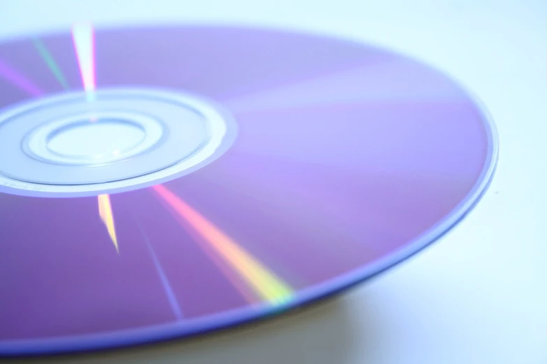 a purple colored cd on a white surface